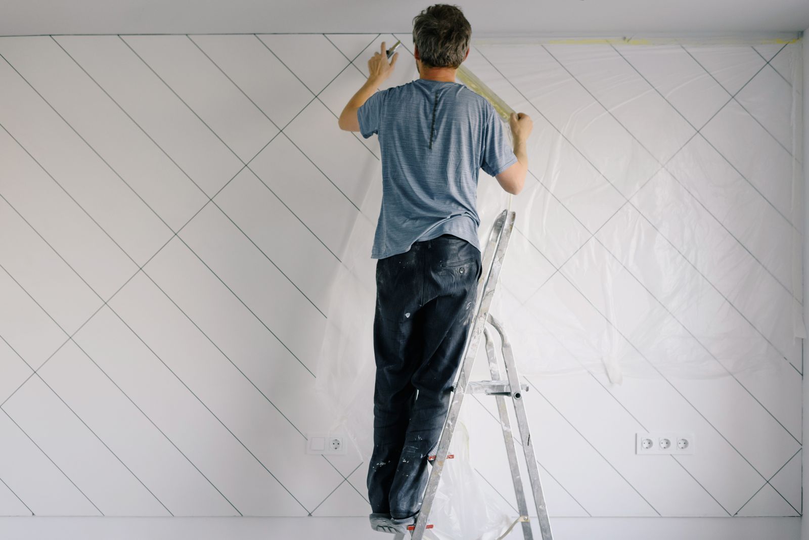 Schilder voert onderhoud uit aan een wand
